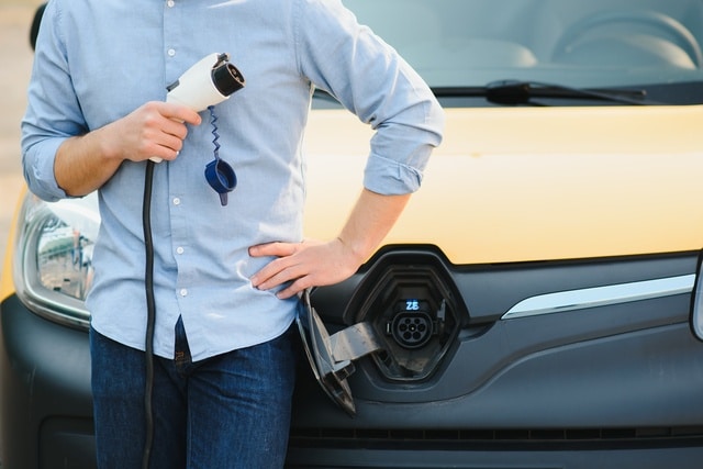 Man charging his electric car at charge station.
